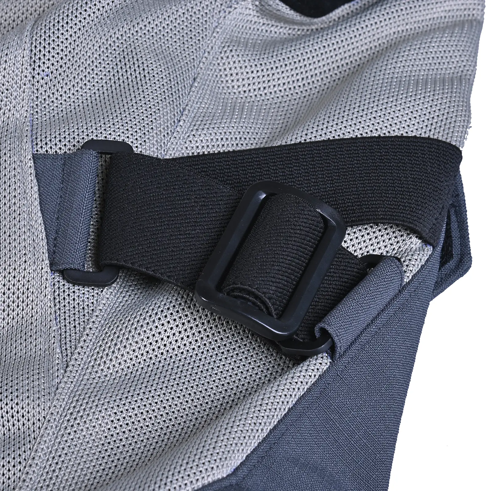 Detalle de tejido de malla transpirable gris claro, tejido textil oscuro y correa de ajuste negra con hebilla rectangular de plástico negro.