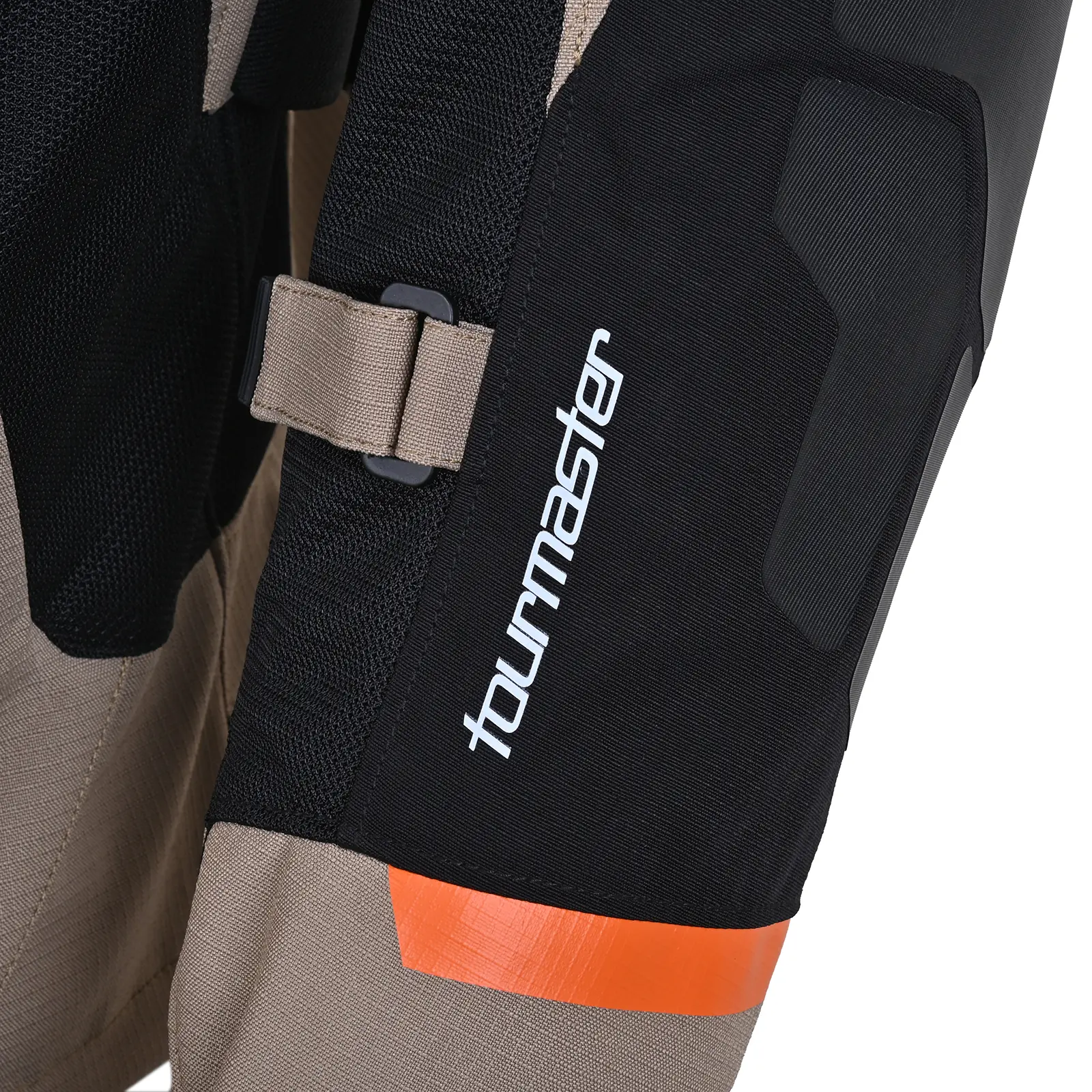 Primer plano de pantalón o chaqueta Tourmaster. Incluye logo blanco, correa ajustable beige, panel de protección negro texturizado y detalle naranja. Colores: negro, beige, naranja.