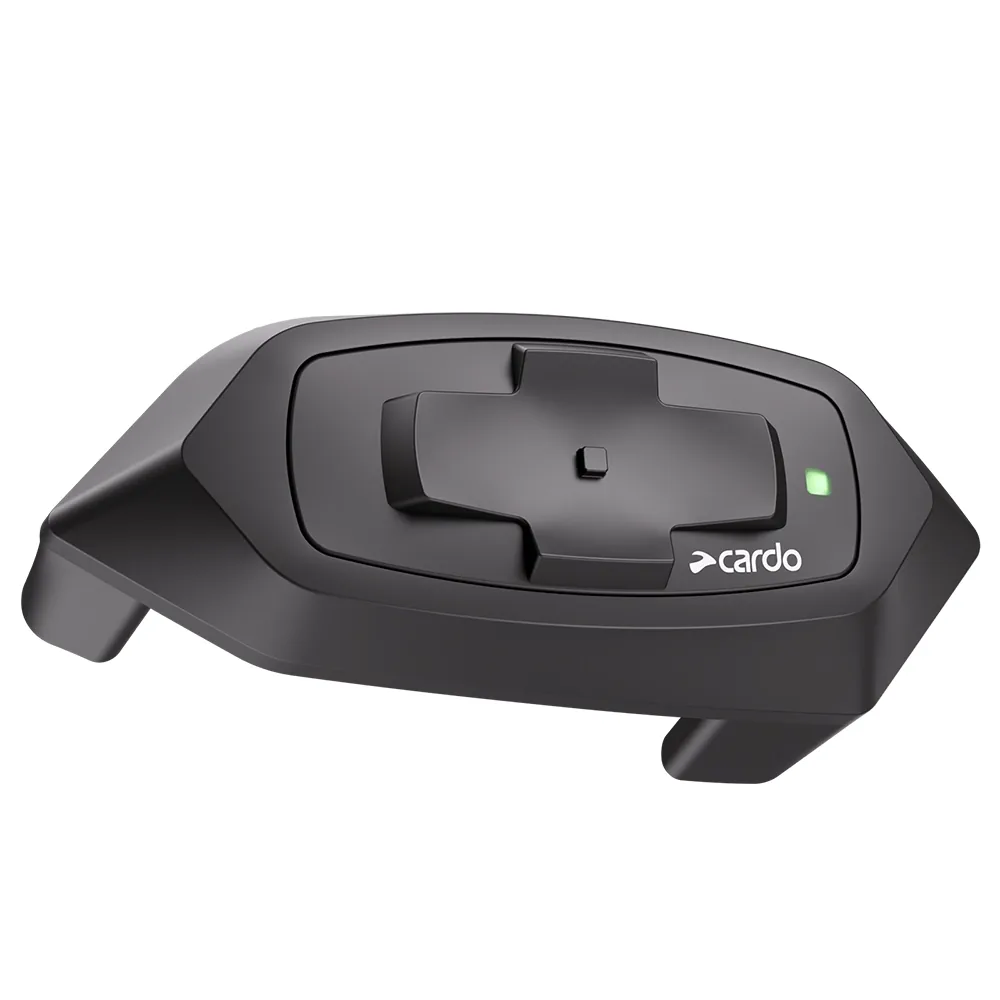 Dispositivo de comunicación Cardo negro para casco de motocicleta con botones de control y luz indicadora verde.