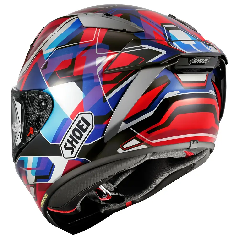 Vista trasera de casco integral Shoei con diseño geométrico multicolor en rojo, azul, negro, blanco y gris. Incluye logo Shoei lateral y detalles aerodinámicos en la parte superior y trasera. Cierre de barbilla visible.