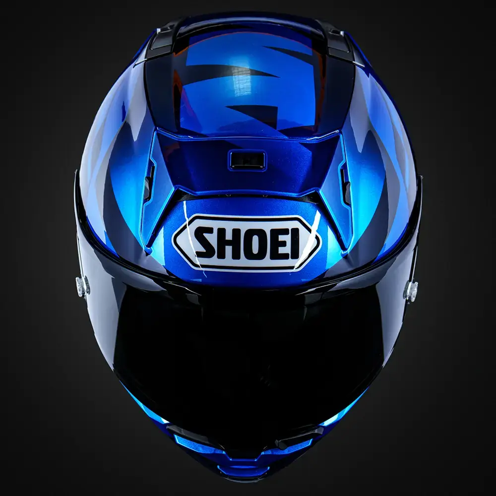 Casco de motocicleta Shoei integral, color azul metálico con gráficos negros y azules claros. Logotipo Shoei blanco en la parte trasera. Visor oscuro.